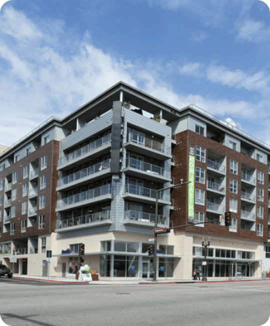 Corner view of a modern mixed-use apartment building with ground-floor retail, the kind of property that hosts a Stuf storage location